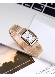 Close-up of rectangular vintage quartz watch with rose gold mesh band on a desk