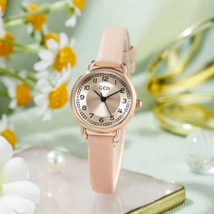 GEDI minimalist women's watch with champagne dial and pink leather strap in floral setting