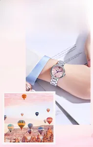 Detail of elegant steel watch with pink dial and Roman numerals on a model's wrist