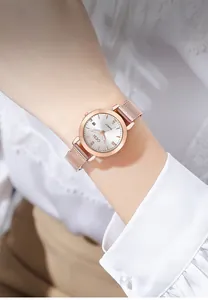 Detail of rose gold mesh strap watch with sparkling crystal markers and date window