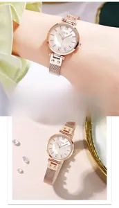 Detail view of rose gold mesh watch with mother of pearl dial and roman numerals