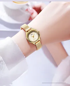 Close-up of a luxury gold mesh strap watch with a square dial on a female wrist