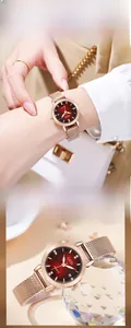 Detail of rose gold mesh steel watch with red gradient dial and sparkling rhinestones