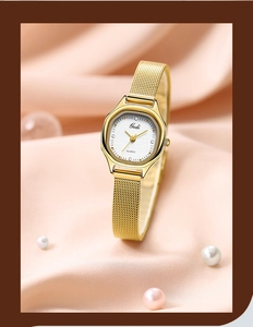 Close-up of gold quartz watch with mesh band on elegant pink silk with pearls