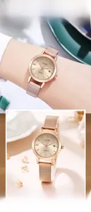 Detail view of rose gold mesh strap watch with crystal markers and date display