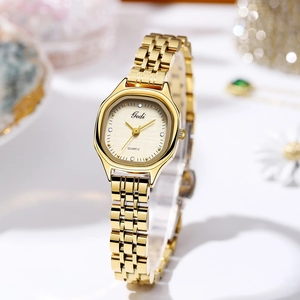 Detailed close-up of a gold octagon quartz watch with a textured dial and gemstones