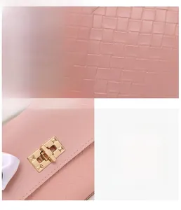 Close-up of pink woven handbag featuring a glossy gold metal buckle and stud details