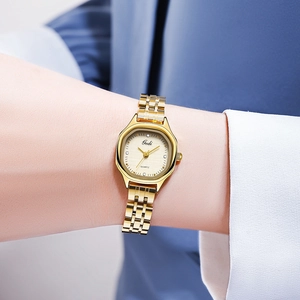 Close-up of elegant gold stainless steel watch with rhinestones on a female wrist