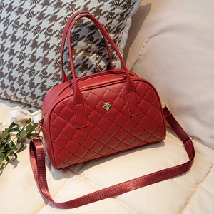 Sac à main matelassé bordeaux avec logo camélia doré et bandoulière tissée réglable