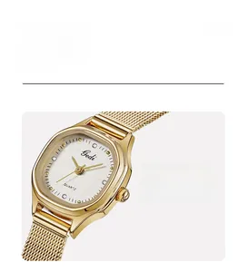 Detail of gold mesh strap and white textured dial with crystals on a quartz watch