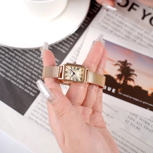 Classic gold square quartz watch with Roman numerals and Milanese mesh strap on woman's wrist