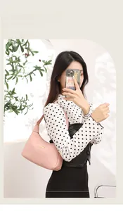 Chic pink lychee texture shoulder bag with metal plate worn by model in a natural setting
