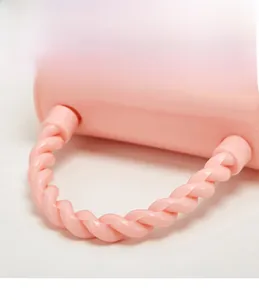 Detail of pink handbag featuring a twisted matte handle with a unique braided design