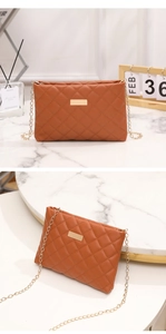Close-up of caramel quilted PU leather mini bag with gold chain and metal buckle detail