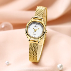 Elegant gold mesh band watch with octagonal case and pearl accents on silk