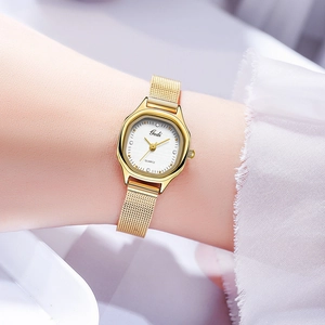 Detail of elegant gold mesh watch with a rectangular dial and crystal markers on wrist
