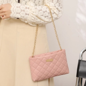 Elegant pink quilted crossbody bag with gold chain strap and metallic plaque detail