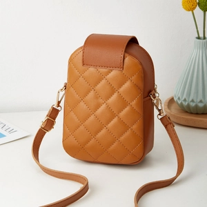 Quilted caramel brown crossbody bag with gold hardware on a minimalist floral background