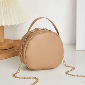 Minimalist round embossed crossbody bag with golden chain strap and top handle in beige