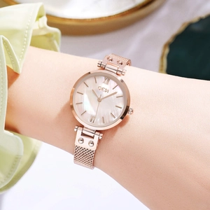 Elegant rose gold women's watch with white mother of pearl dial and mesh strap on wrist