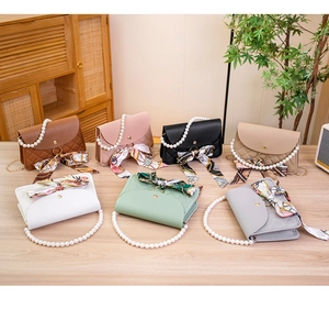 Detailed view of quilted leather handbags with pearl handles and decorative silk scarves