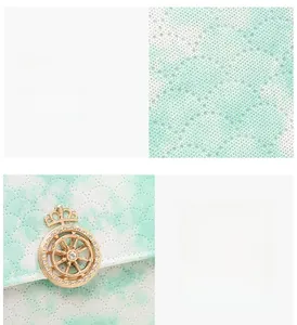 Macro shot of mint green lace fabric texture and gold rhinestone crown buckle detail