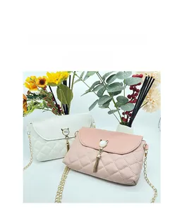 Close-up of cat-shaped metal clasp and golden tassel on quilted chain crossbody bag