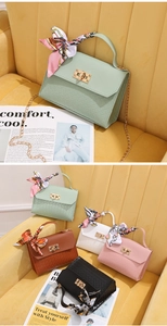 Detail of woven texture faux leather bag with silk scarf handle and gold twist lock