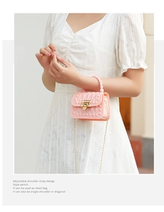 Pink mini jelly bag featuring tonal studs, gold chain strap, and woven top handle detail
