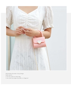 Detail of pink silicone mini bag featuring a silver heart buckle and metal chain strap