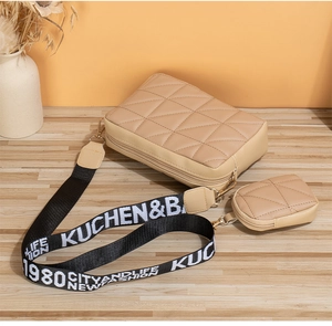 Détail du sac bandoulière beige matelassé avec pochette ronde et sangle tissée large