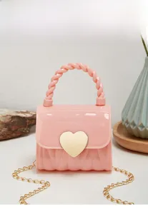 Detailed view of pink mini silicone jelly bag with golden heart clasp and twisted handle