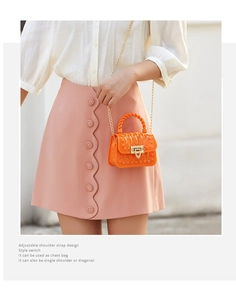 Close-up of bright orange PVC jelly bag featuring gold clasp and removable chain strap