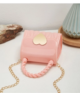 Detail of pink jelly mini handbag with golden heart clasp and spiral handle texture
