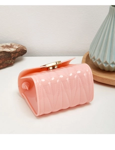 Detail of pink jelly mini bag with diamond quilting and gold circular metal lock