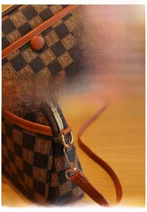 Détail du sac bandoulière vintage marron à damier avec zip doré et boucle métallique