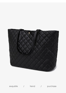 Close-up of black quilted tote bag with diamond stitching and gold magnetic closure
