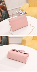 Detailed macro of pink woven texture crossbody bag with gold chain and silk scarf decor
