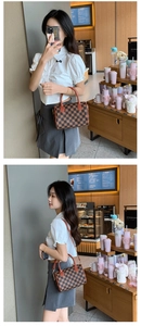 Classic checkered boston bag with brown handles in a cozy cafe setting for women