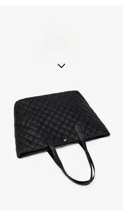 Detailed top view of a black quilted tote bag with diamond pattern and gold closure