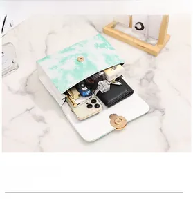 Top view of white crossbody bag interior showing storage space for phone and wallet