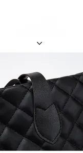 Macro detail of black quilted leather tote bag showcasing premium stitching and texture