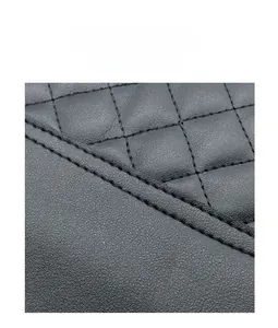 Detailed macro view of quilted diamond stitching on black leather handbag chain strap