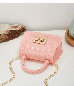 Pink mini jelly bag with rivet texture, gold chain strap and twist handle detail