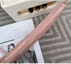 Détail du sac à main matelassé rose montrant la fermeture éclair et les surpiqûres