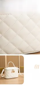 Détails macro d'une trousse à maquillage matelassée crème avec fermetures dorées