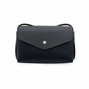 Macro detail of black envelope mini crossbody bag featuring a silver metal button closure