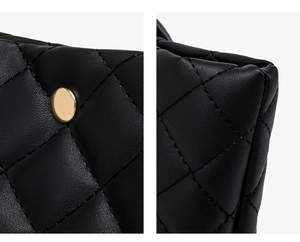 Detail of black quilted tote bag with golden rivet and premium leather stitching finish