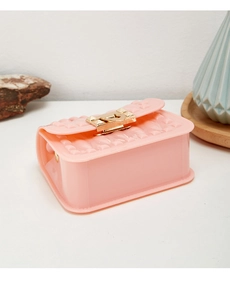 Detailed close-up of pink mini jelly bag with geometric rivets and gold metal lock