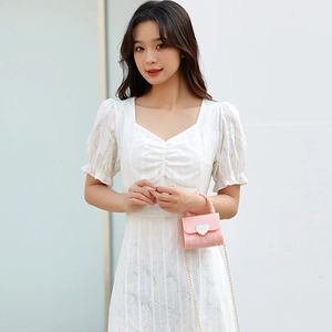 Mini sac rose en silicone avec cœur et chaîne dorée, porté par un mannequin en plein air